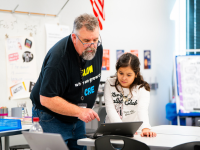 student and staff member looking at computer